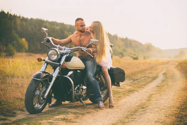 Lovers on a motorcycle in a field — Stock Photo, Image