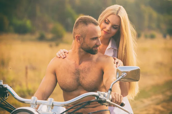 Lovers on a motorcycle in a field — Stock Photo, Image