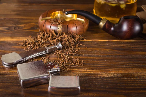 Smoking pipe, whiskey on a wooden background. — Stock Photo, Image