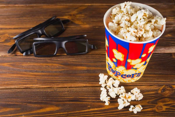 Popcorn und Gläser auf Holzgrund. — Stockfoto