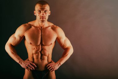 Karanlık bir arka plan üzerinde büyük vücut geliştirmeci