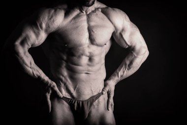 Karanlık bir arka plan üzerinde vücut geliştirmeci.