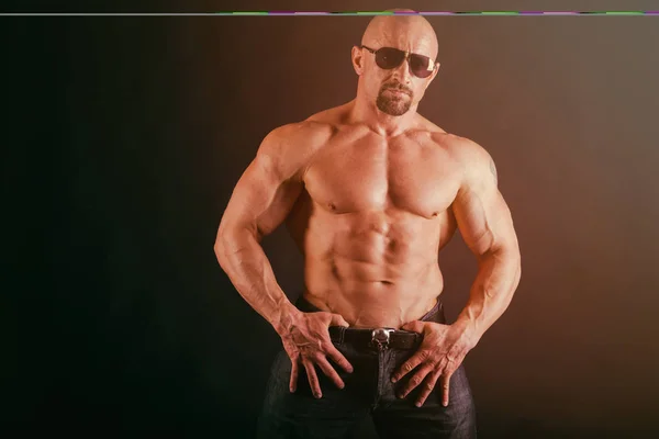 Bodybuilder auf dunklem Hintergrund. — Stockfoto