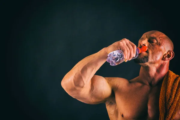 Bodybuilder  on a dark background. — Stock Photo, Image