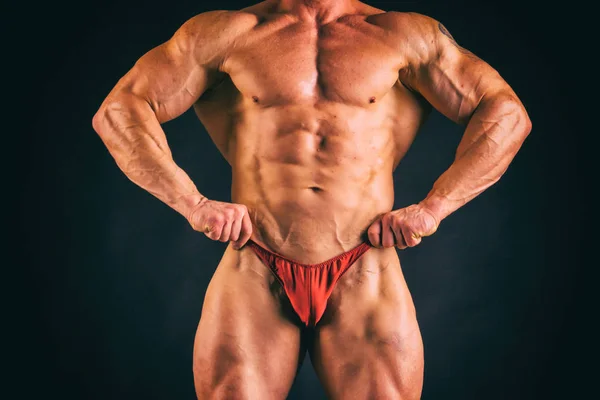 Bodybuilder på en mörk bakgrund. — Stockfoto