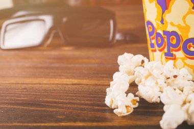 Gevşek patlamış mısır ve ahşap arka plan üzerinde 3d gözlük
