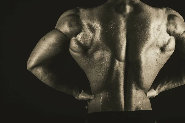 Hombre atlético guapo muy musculoso sobre fondo negro —  Fotos de Stock