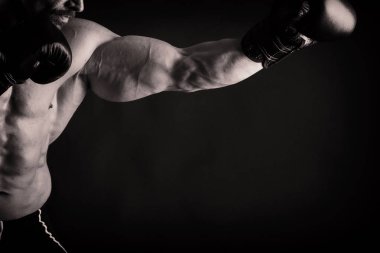 Bir adam siyah bir zemin üzerine muhteşem bir kas vücut ile