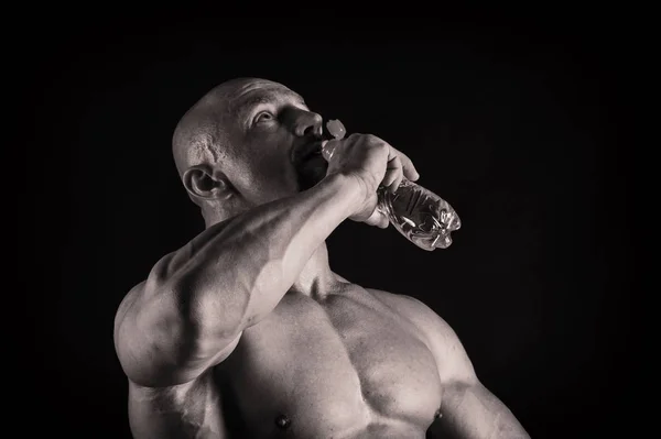 Ein Mann mit einem wunderschönen muskulösen Körper auf schwarzem Hintergrund — Stockfoto
