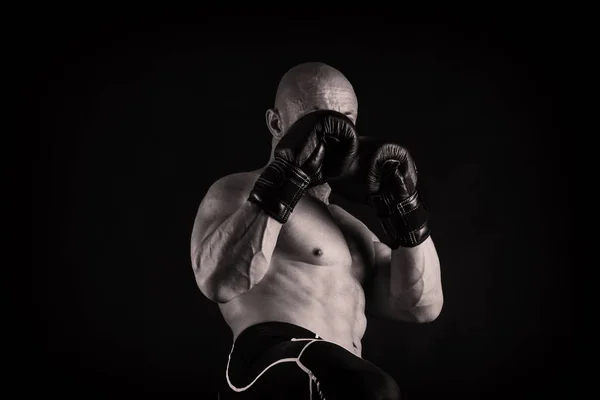 Un hombre con un cuerpo musculoso magnífico sobre un fondo negro — Foto de Stock