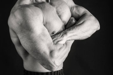 Karanlık bir arka plan üzerinde vücut geliştirmeci.