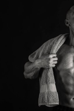 Karanlık bir arka plan üzerinde vücut geliştirmeci.