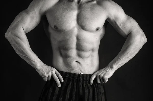 Bodybuilder op een zwarte achtergrond. — Stockfoto