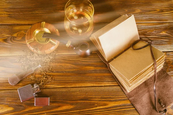 Sigara boru ve masanın üstünde defter
