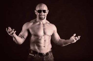 Karanlık bir arka plan üzerinde vücut geliştirmeci.