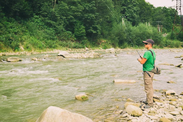 Pesca alla trota su un fiume di montagna. Pesca sportiva . — Foto Stock