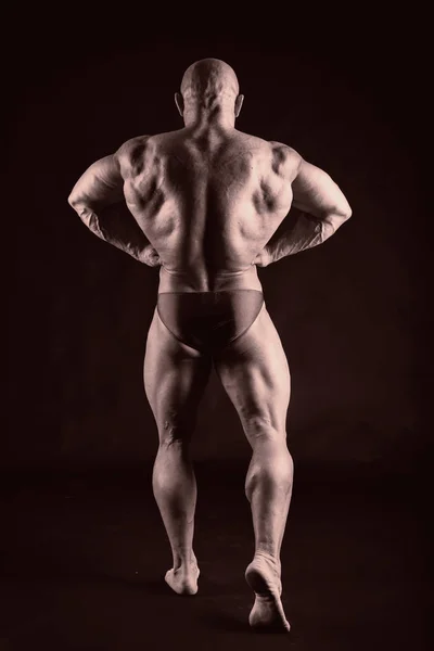 Bodybuilder auf dunklem Hintergrund. — Stockfoto