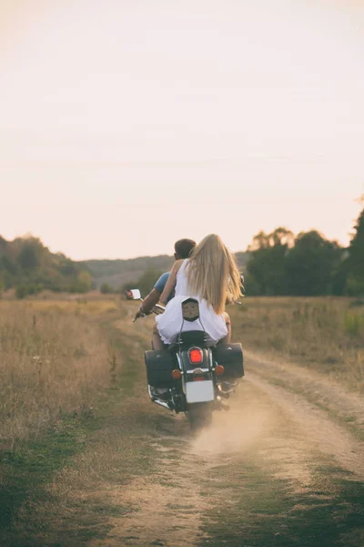 Молодая пара на мотоцикле в поле — стоковое фото