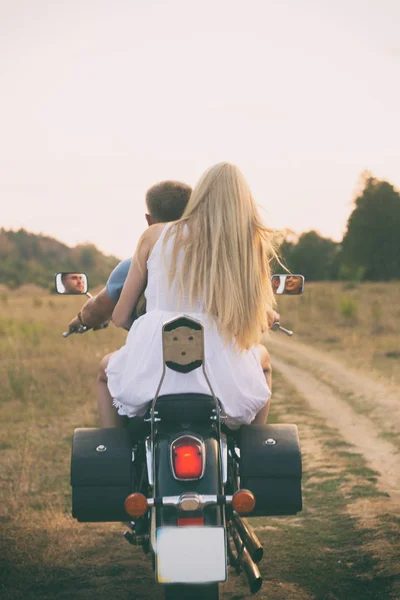 Jovem casal em uma motocicleta no campo — Fotografia de Stock