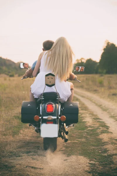 Νεαρό ζευγάρι σε μια μοτοσικλέτα στο πεδίο — Φωτογραφία Αρχείου