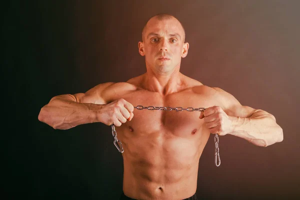 Muskulös manliga kroppen på en mörk bakgrund. — Stockfoto