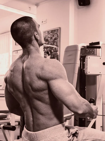 Um homem com um exercício de sino no bíceps — Fotografia de Stock