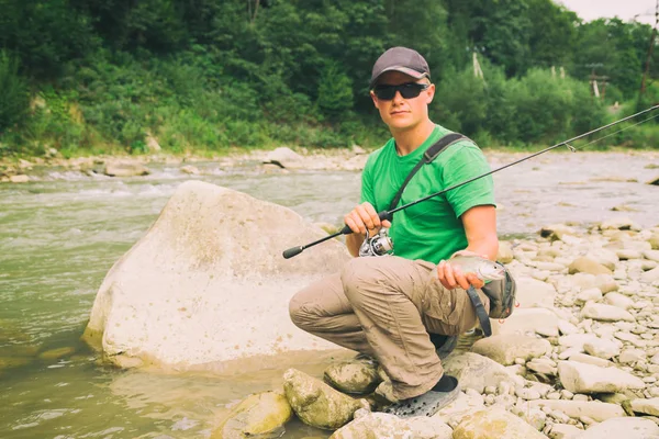 Pesca alla trota su un fiume di montagna. Pesca sportiva . — Foto Stock