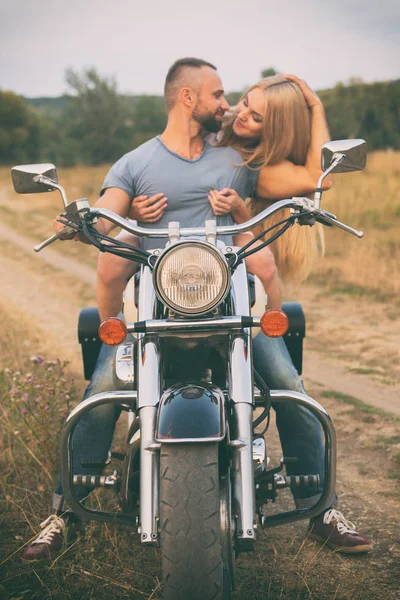 Viagens e amor, paixão, estrada de bicicleta. Casal apaixonado na estrada com uma motocicleta. Menino e menina apaixonados . — Fotografia de Stock