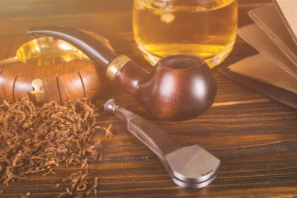 Sigara boru, viski ahşap arka plan üzerinde.