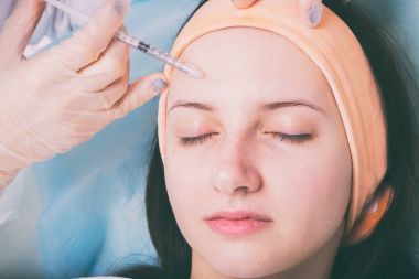 Kozmetik enjeksiyon spa salonda. Güzellik uzmanı hastanın yüz içine enjeksiyon yapar.