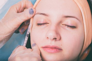 Kozmetik enjeksiyon spa salonda. Güzellik uzmanı hastanın yüz içine enjeksiyon yapar.