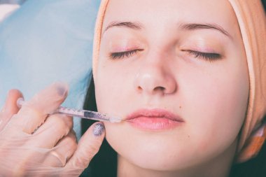 Kozmetik enjeksiyon spa salonda. Güzellik uzmanı hastanın yüz içine enjeksiyon yapar.