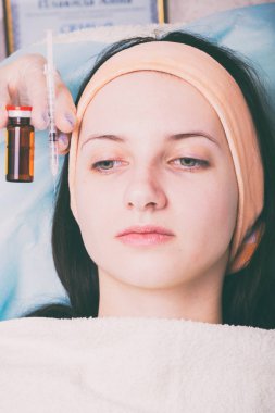 Kozmetik enjeksiyon spa salonda. Güzellik uzmanı hastanın yüz içine enjeksiyon yapar.
