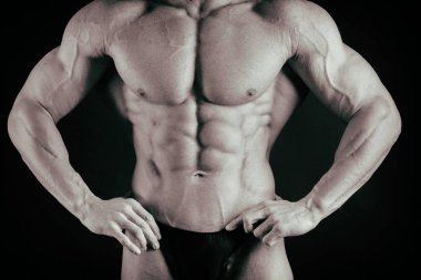 Karanlık bir arka plan üzerinde vücut geliştirmeci.