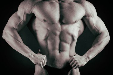 Karanlık bir arka plan üzerinde vücut geliştirmeci.