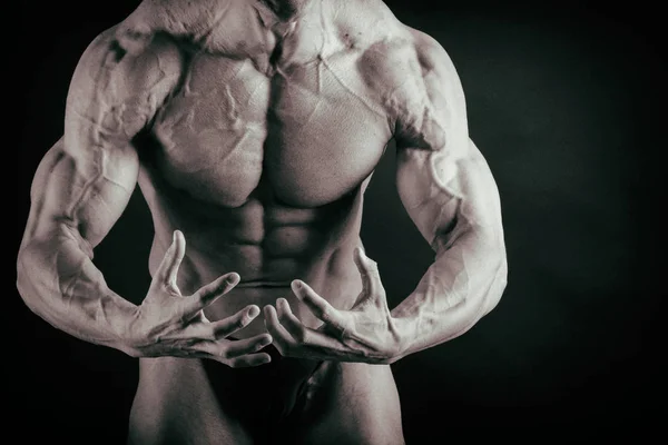 Bodybuilder sur fond sombre . — Photo