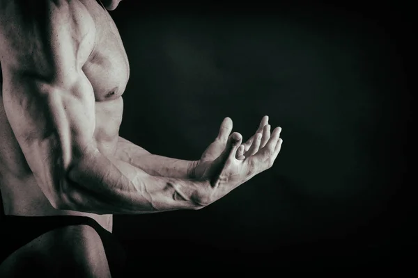 Bodybuilder on a dark background. — Stock Photo, Image