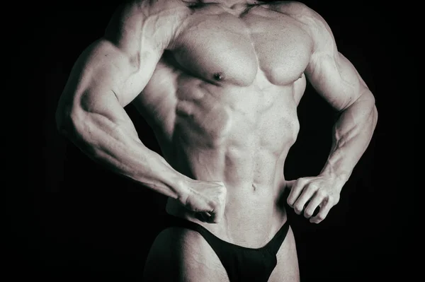Bodybuilder op een donkere achtergrond. — Stockfoto