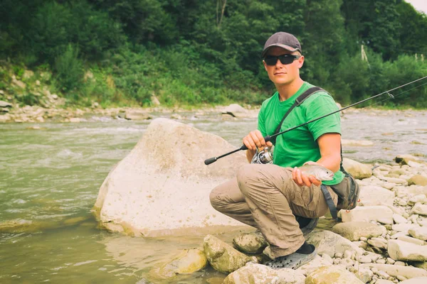 Pesca alla trota su un fiume di montagna. Pesca sportiva . — Foto Stock