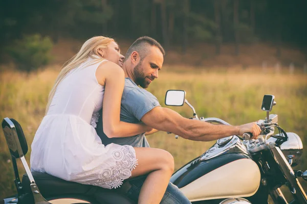 Young couple on a motorcycle in the field — Stock Photo, Image