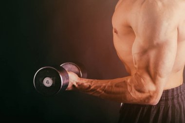 kaslı erkek vücut karanlık bir arka plan üzerinde.