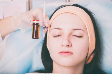 Kozmetik enjeksiyon spa salonda. Güzellik uzmanı hastanın yüz içine enjeksiyon yapar.