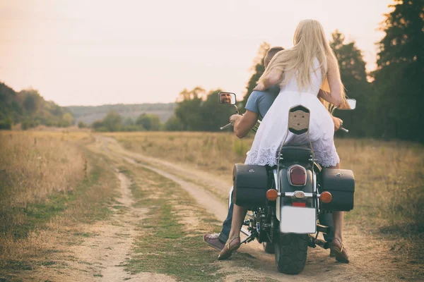 Pasangan muda di atas sepeda motor di lapangan — Stok Foto