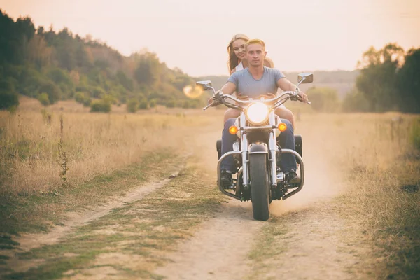 Young couple on a motorcycle in the field