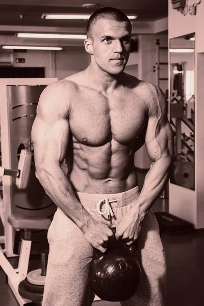 En man med en skivstång tränar biceps — Stockfoto