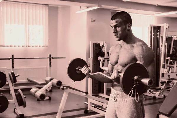 Un homme avec un exercice d'haltère sur biceps — Photo