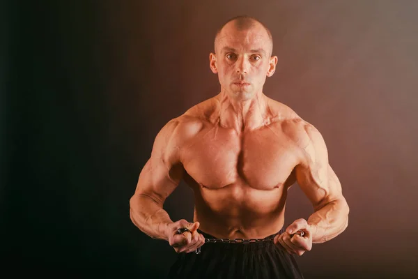 Muskulös manliga kroppen på en mörk bakgrund. — Stockfoto