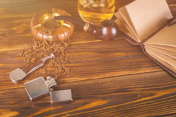 Smoking pipe, whiskey on a wooden background. — Stock Photo, Image