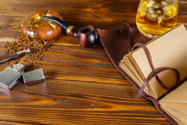 Sigara boru ve masanın üstünde defter