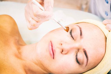 Yüz germe. Genç kadın. Yüz Cilt Bakımı. Yordam kaldırma. Cos